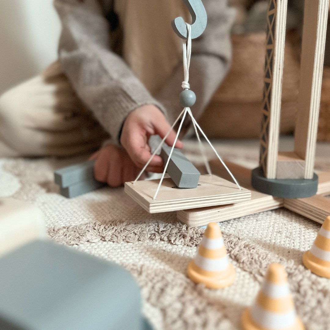 Drevené stavenisko s veľkým mobilným žeriavom a vozidlami, vežový žeriav