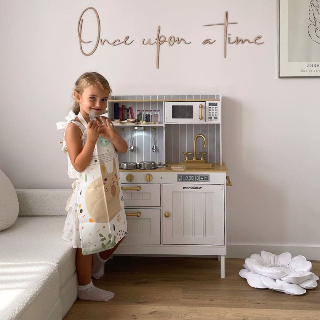 Drevená biela kuchyňa s príslušenstvom a zásterou